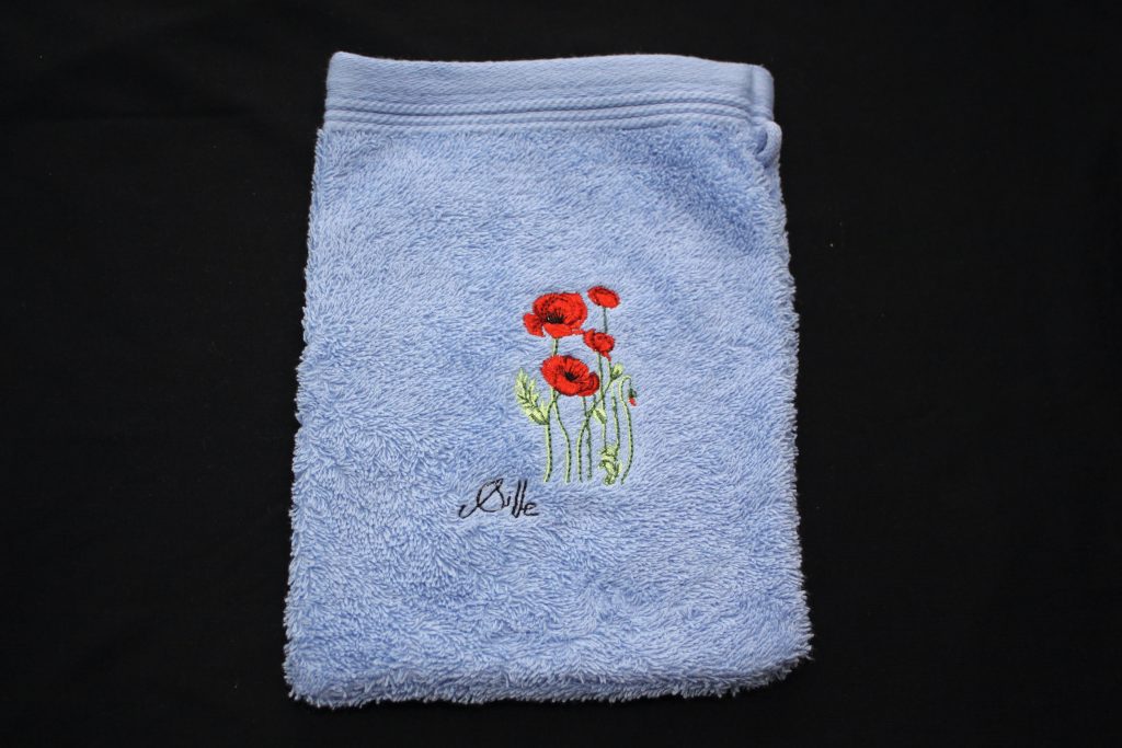 Gant de toilette bleu avec broderie de coquelicots, fabriqué en France par des artisans.